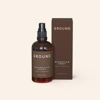 Image of a glass bottle and box of Ground Magnesium Spray on a beige background. The details on the packaging are: Ground Magnesium Spray, Spray Au Magnesium, 100ml / 3.4 fl oz.