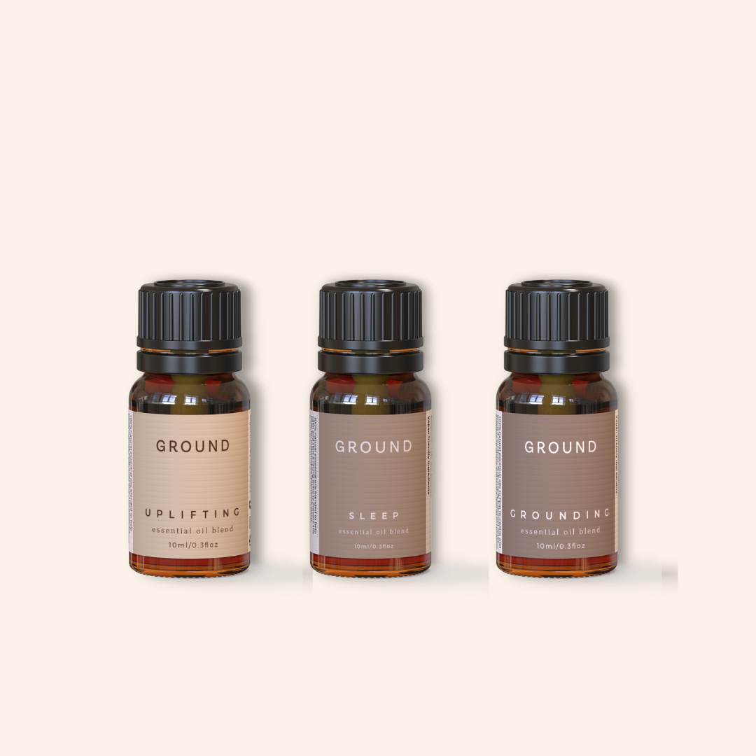Three essential oil bottles labelled 'Ground', with different scents on a beige background. One oil is for Uplifting, One is for Sleep and the other is for Grounding the body and nervous system.