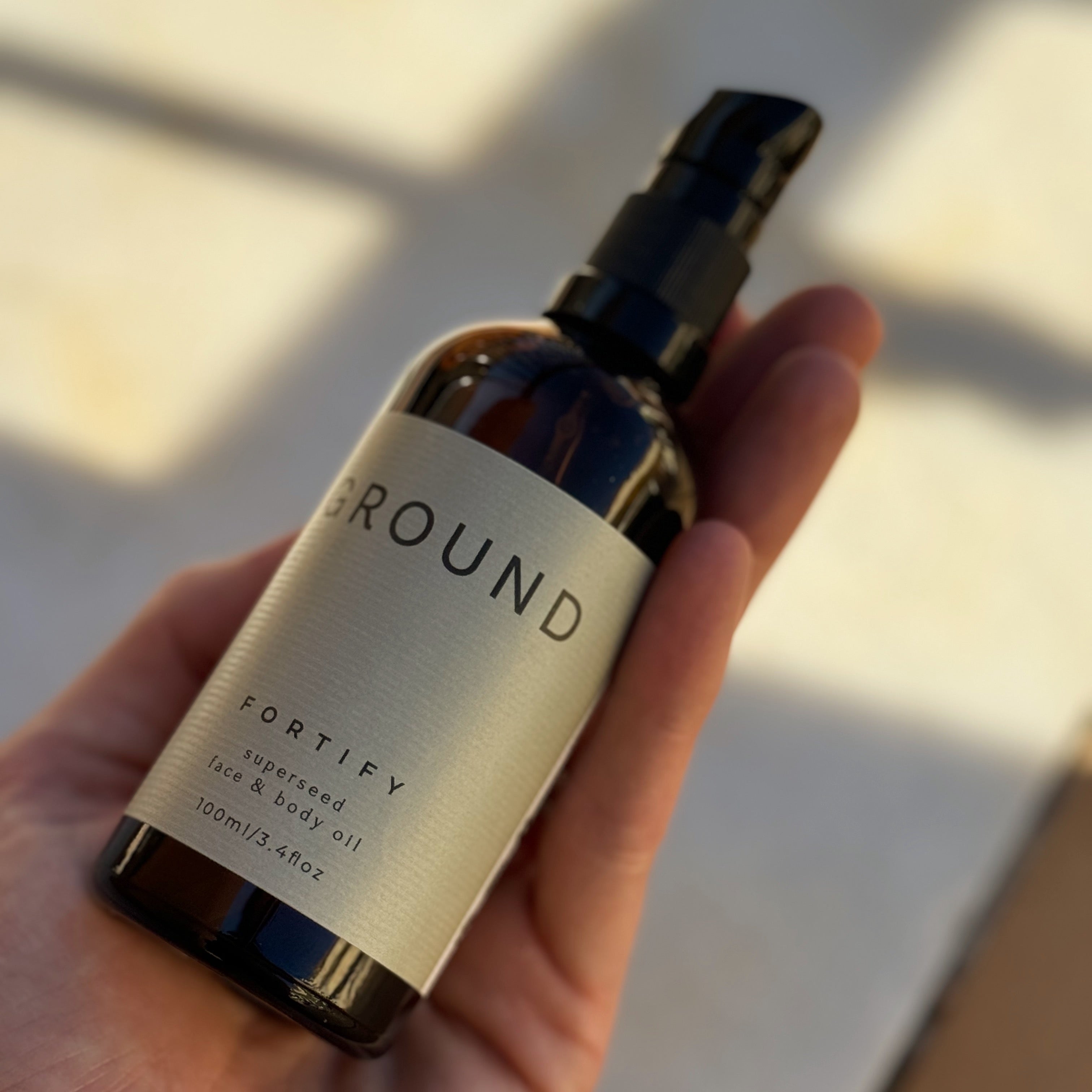 Image of a 100ml pump bottle of Fortify superseed face and body oil- 3.4 fl oz.