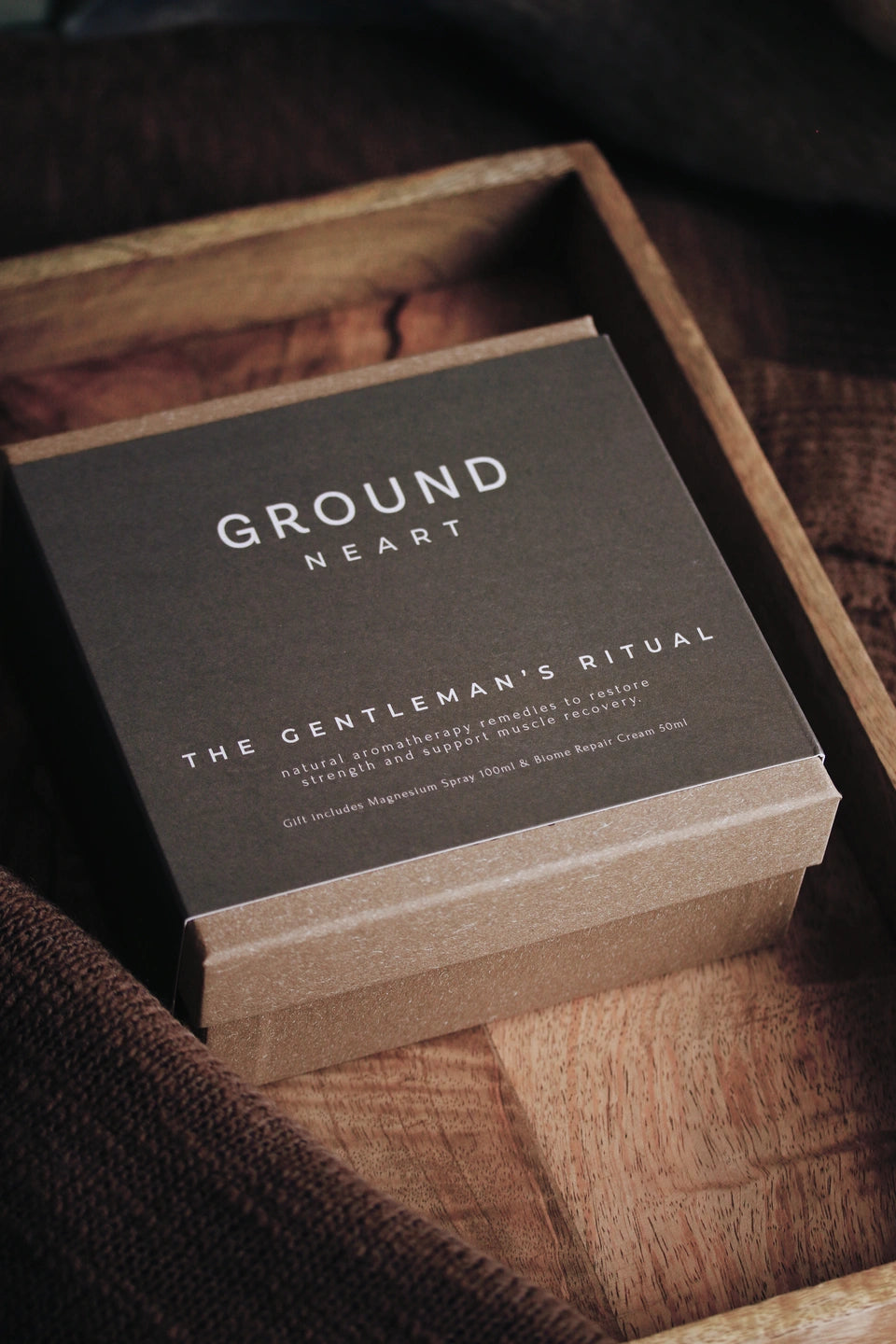A photo of Ground Wellbeing's Neart The Gentleman's Ritual gift box on a wooden surface.