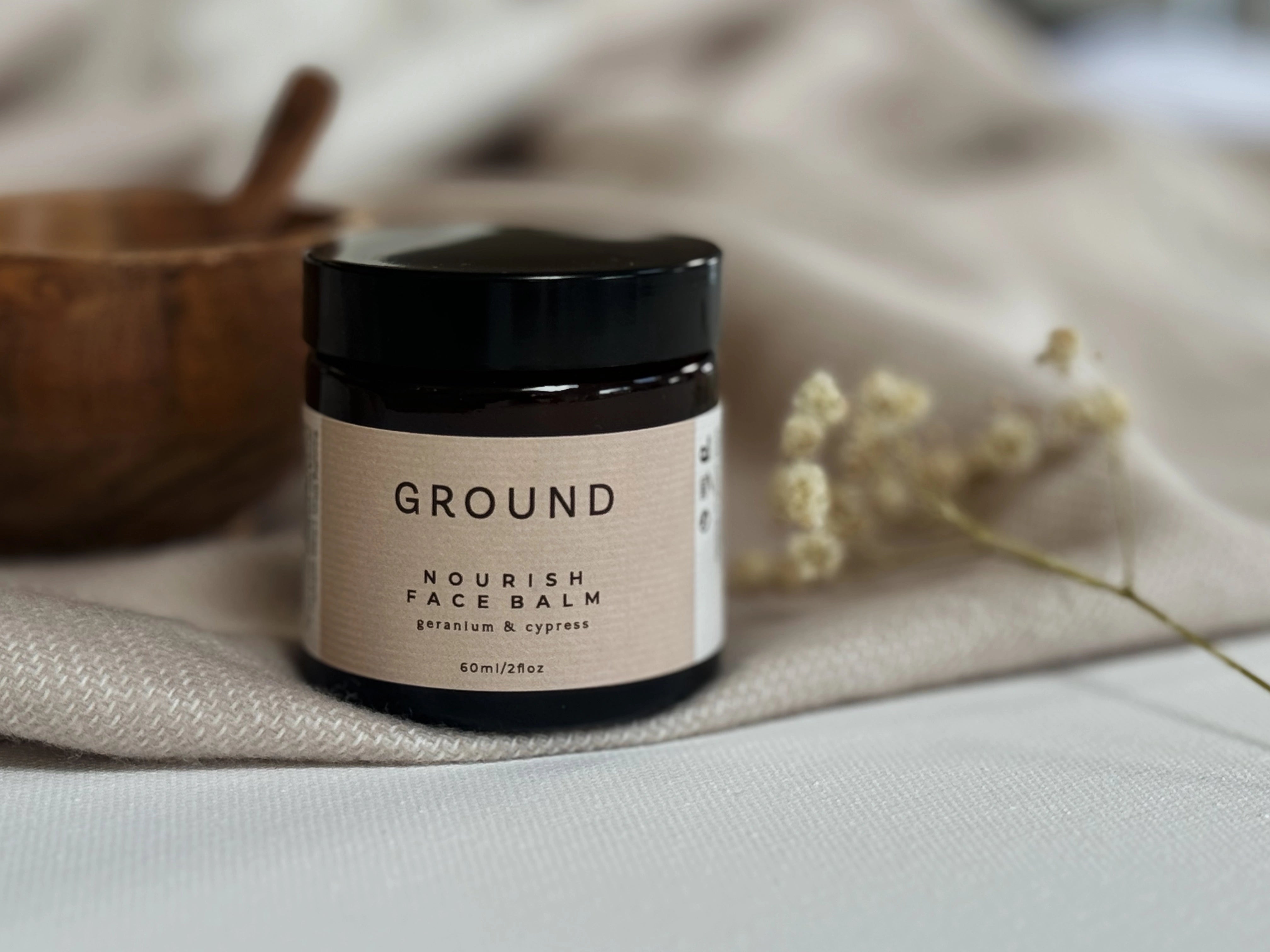 Photograph of a glass jar of Ground Nourish Face Balm containing geranium and cypress.
